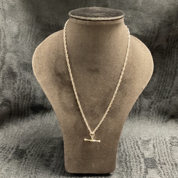Delicate 925 silver T bar necklace on display.