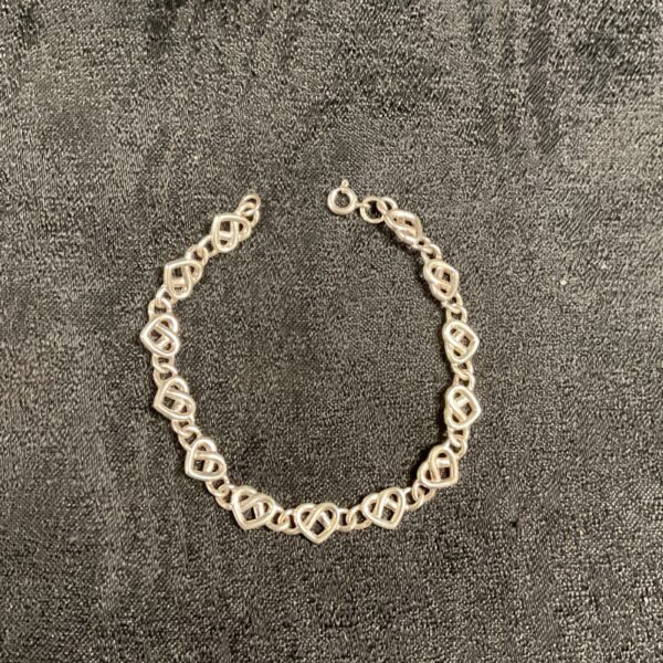 Close-up of 935 silver heart link bracelet with delicate chain.