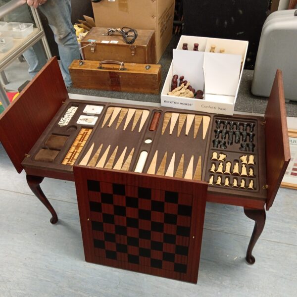 Open chess and checkers coffee table showing game boards and pieces.