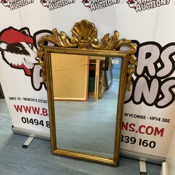 Ornate gilt framed boudoir mirror with clamshell finial.