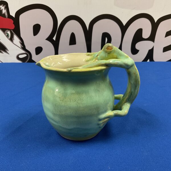 Front view of a green studio pottery gecko jug.