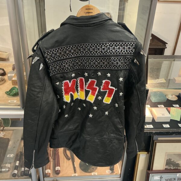 Vintage Kiss leather jacket displayed in a cabinet.