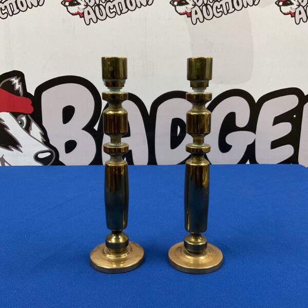 Pair of vintage mid-century brass candlesticks on a dark surface.