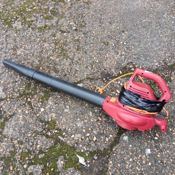Red electric garden blower for clearing leaves and garden debris.