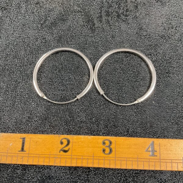 Close-up of large silver hoop earrings, showcasing the quality silver.