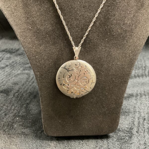 Intricate silver locket on a delicate necklace, vintage jewellery.