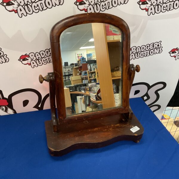 Vintage wooden dresser mirror on a white surface.